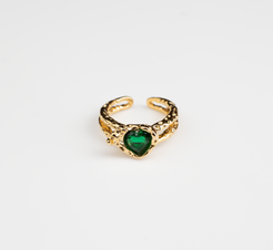 This is an open adjustable ring with a heart-shaped ring face, featuring a sparkling green gemstone embedded within the heart-shaped surface. The ring band, crafted from titanium steel plated with 18K gold, showcases an intricate hollow design and an open setting, suitable for hands of various sizes.