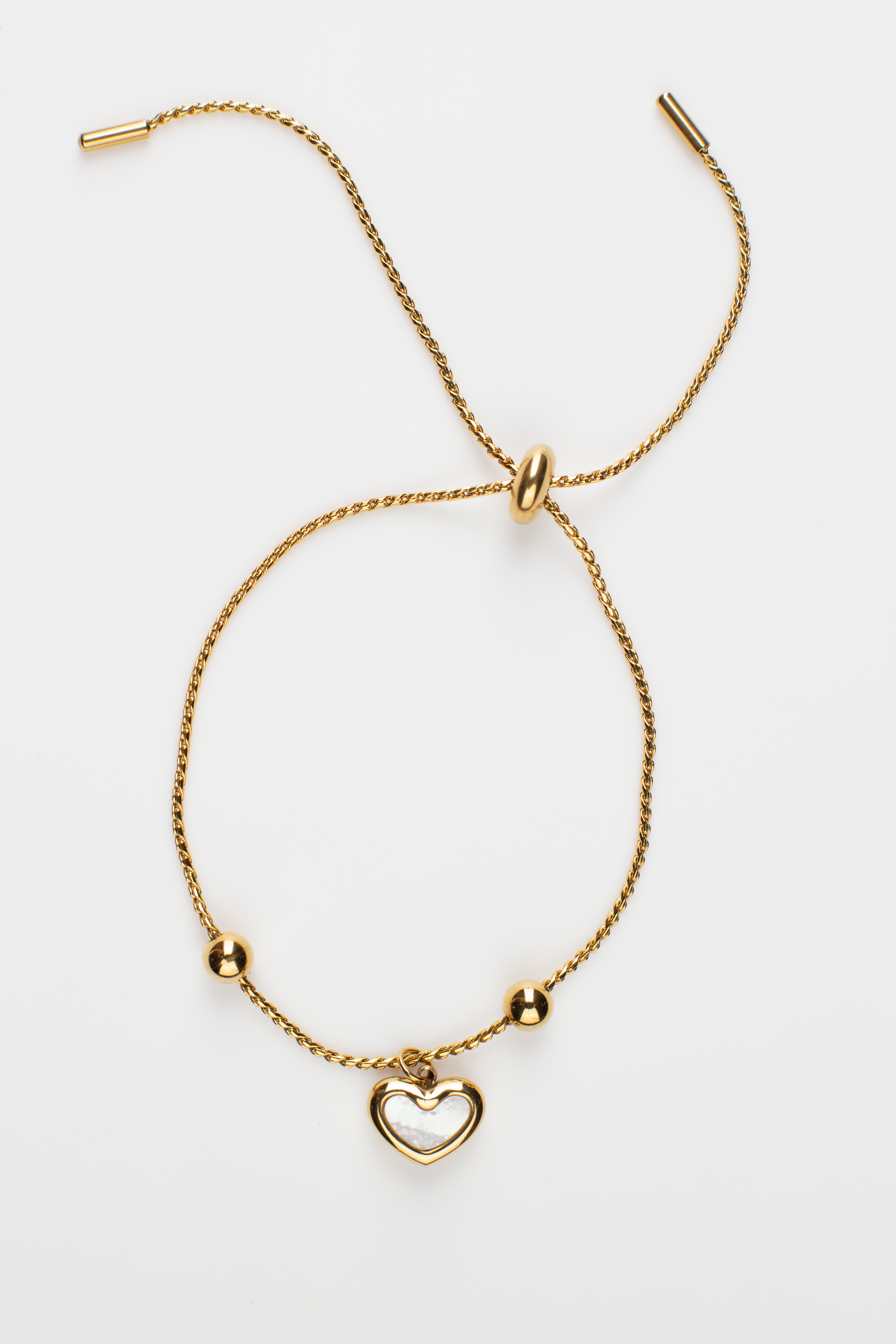 Crafted from titanium steel plated with 18K gold, our bracelet features a heart-shaped pendant adorned with two small gold balls on each side, set on a chain with adjustable size. Simple, stylish, and cute, perfect for casual wear, it's an excellent gift for young women.