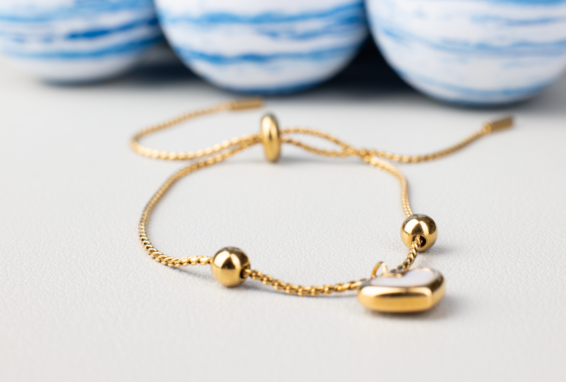 Crafted from titanium steel plated with 18K gold, our bracelet features a heart-shaped pendant adorned with two small gold balls on each side, set on a chain with adjustable size. Simple, stylish, and cute, perfect for casual wear, it's an excellent gift for young women.