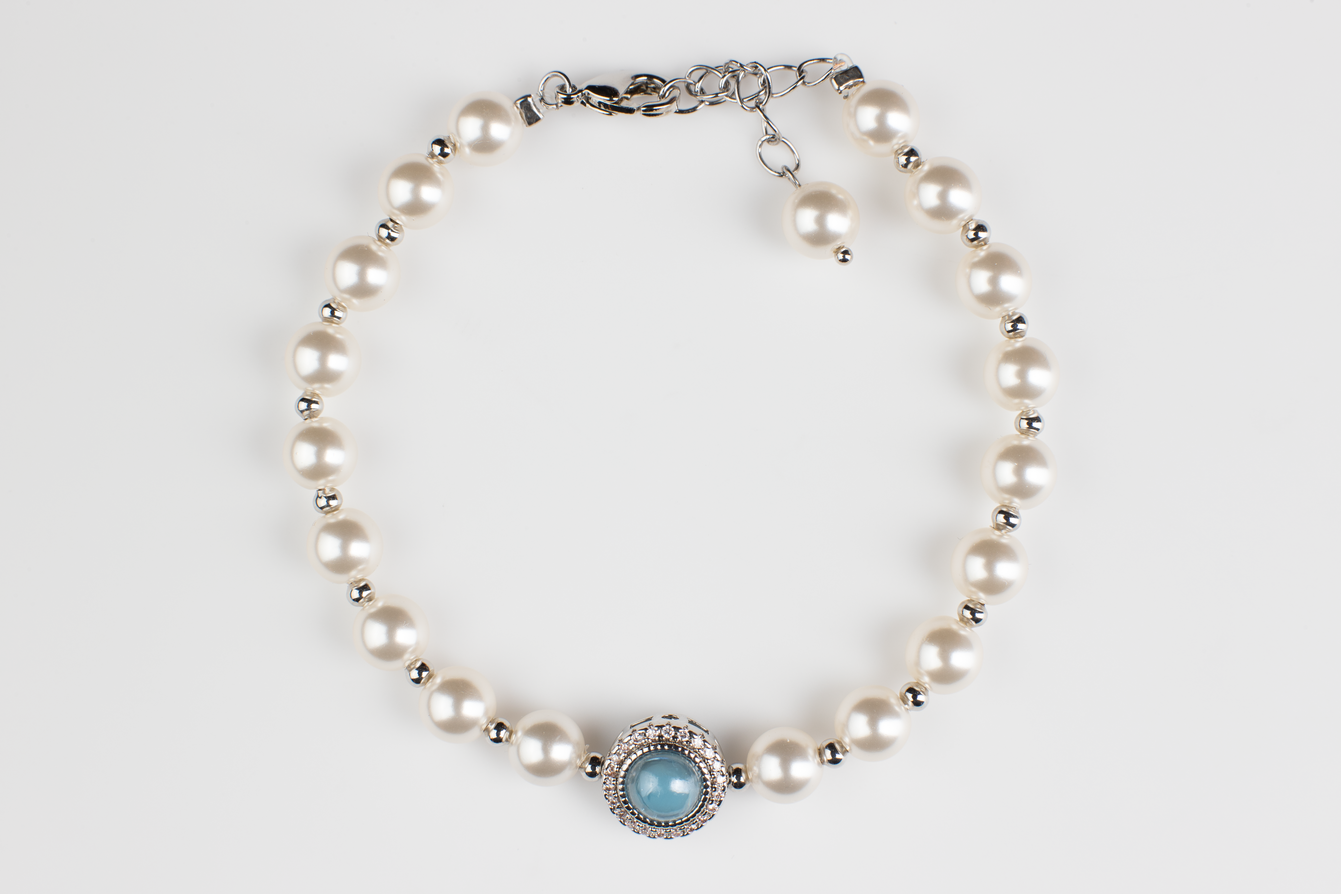 Adjustable in size, our bracelet offers both white and silver pearl options adorned with blue gemstones, exuding elegance and sophistication. Suitable for formal occasions and everyday wear, this women's bracelet makes an elegant gift choice.