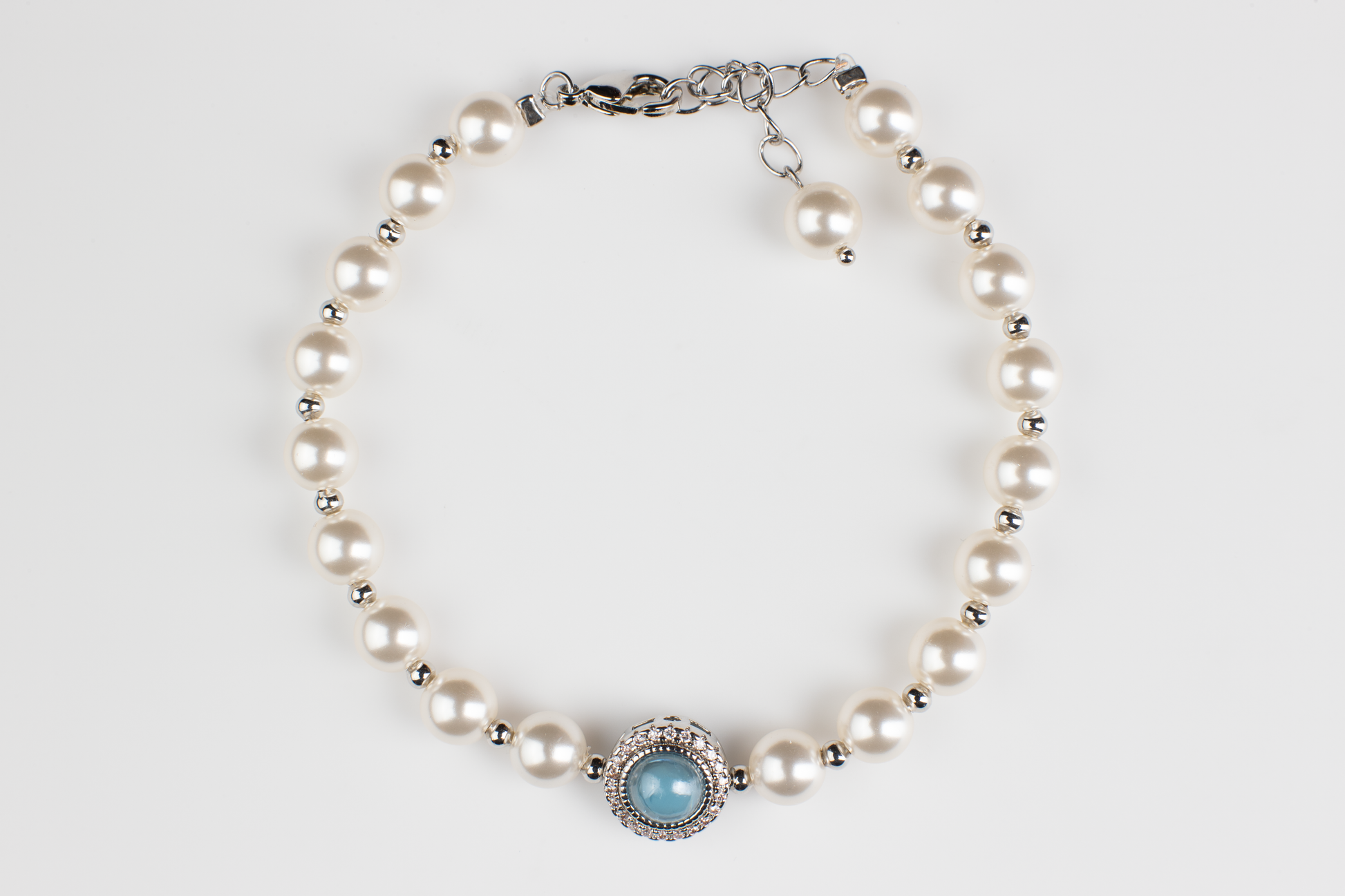 Adjustable in size, our bracelet offers both white and silver pearl options adorned with blue gemstones, exuding elegance and sophistication. Suitable for formal occasions and everyday wear, this women's bracelet makes an elegant gift choice.