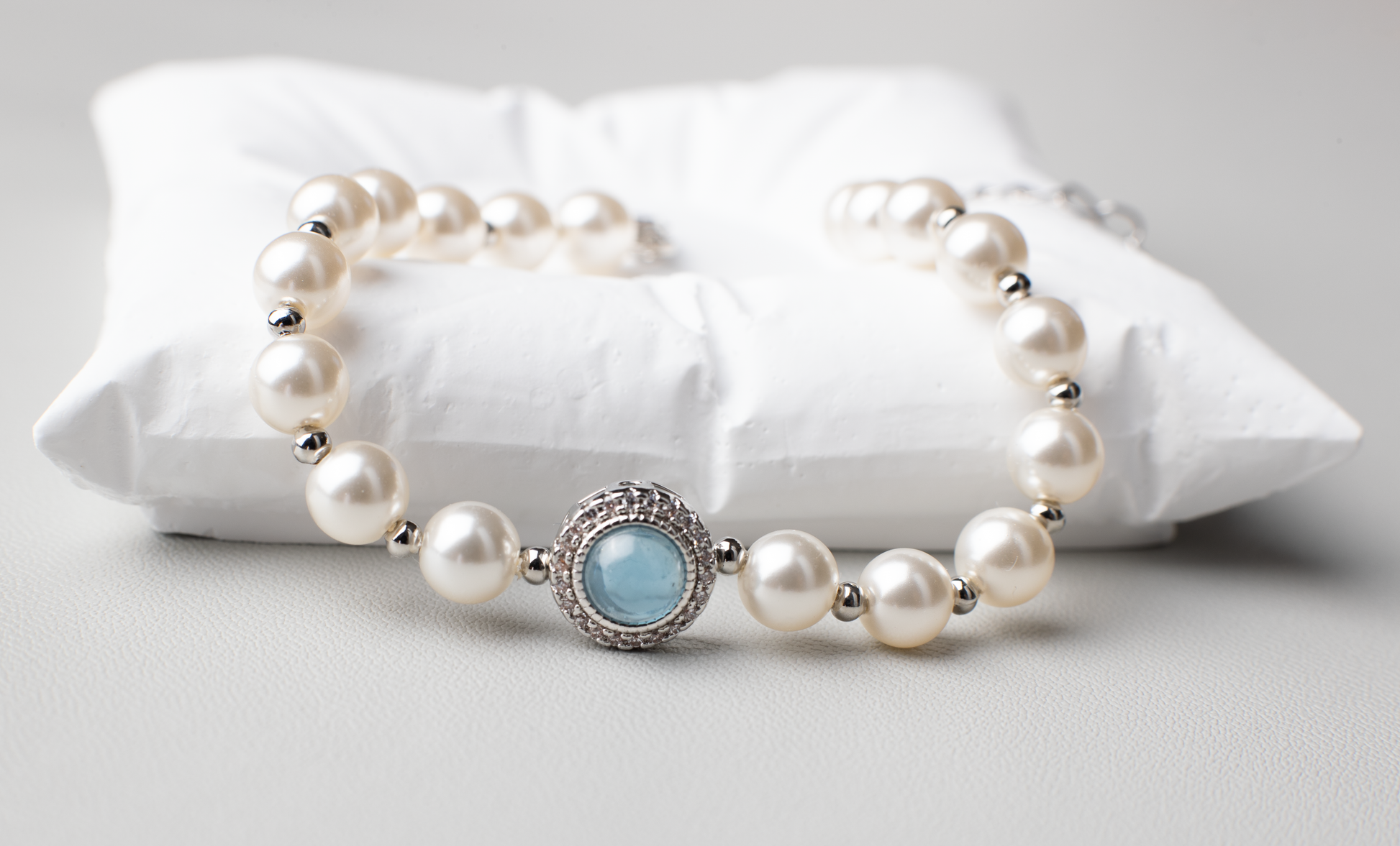 Adjustable in size, our bracelet offers both white and silver pearl options adorned with blue gemstones, exuding elegance and sophistication. Suitable for formal occasions and everyday wear, this women's bracelet makes an elegant gift choice.