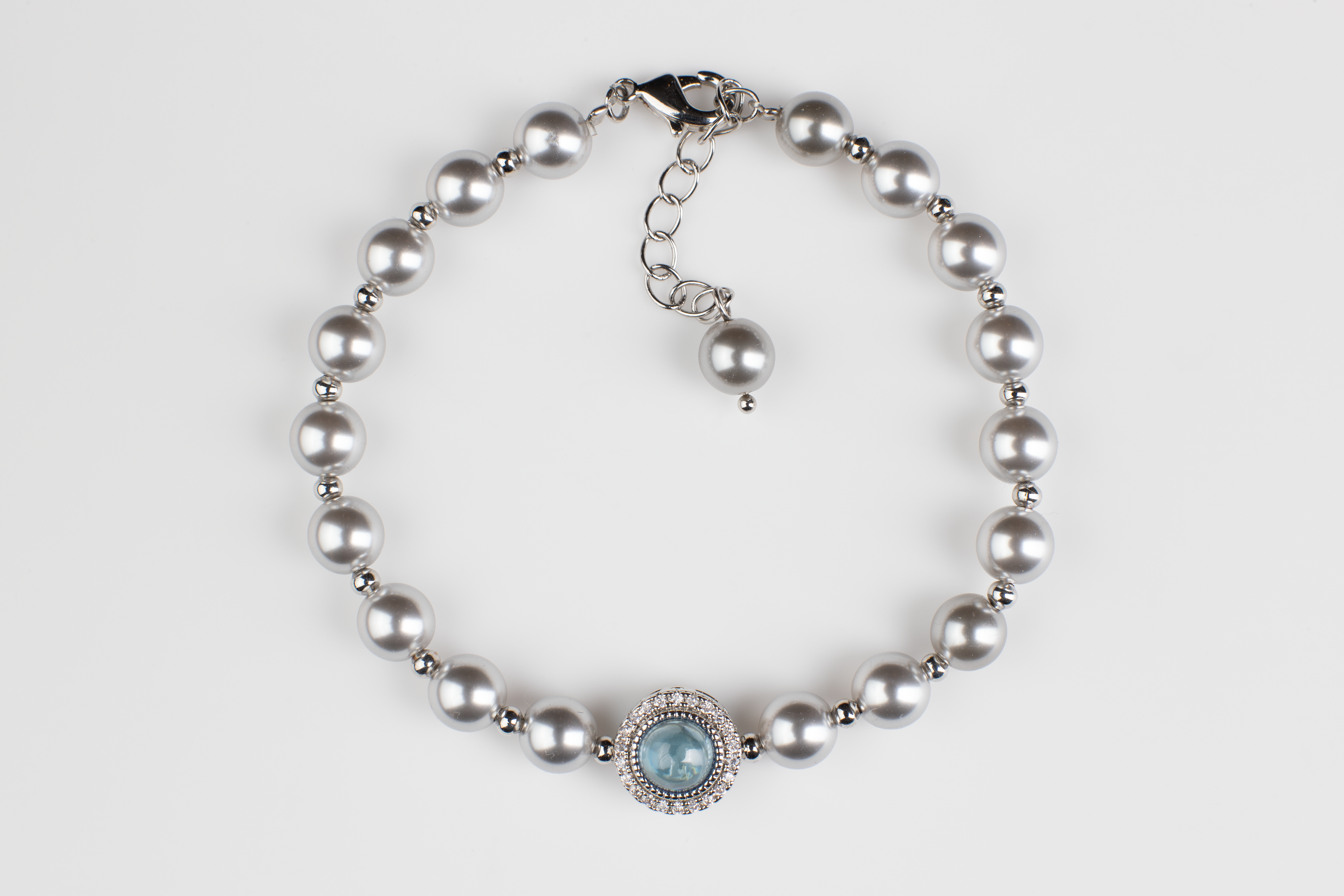 Adjustable in size, our bracelet offers both white and silver pearl options adorned with blue gemstones, exuding elegance and sophistication. Suitable for formal occasions and everyday wear, this women's bracelet makes an elegant gift choice.