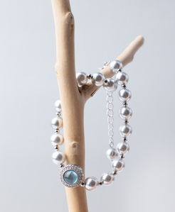 Adjustable in size, our bracelet offers both white and silver pearl options adorned with blue gemstones, exuding elegance and sophistication. Suitable for formal occasions and everyday wear, this women's bracelet makes an elegant gift choice.