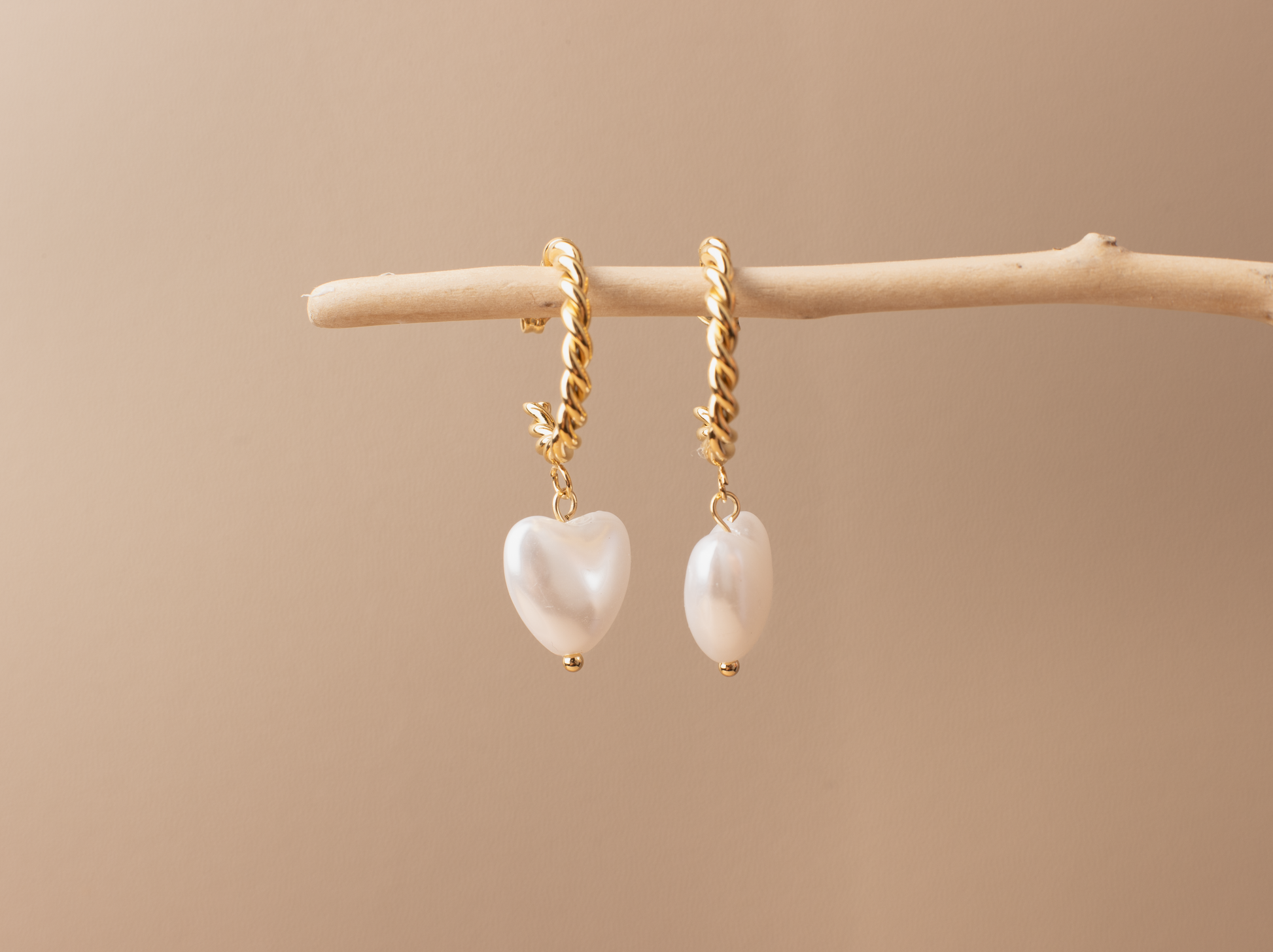 Enhance your elegance with these chic gold earrings adorned with white heart-shaped pearls, perfect for women of all occasions. Crafted from titanium steel plated with 18K gold, they're versatile for formal affairs or leisurely outings. An ideal gift selection for someone special.