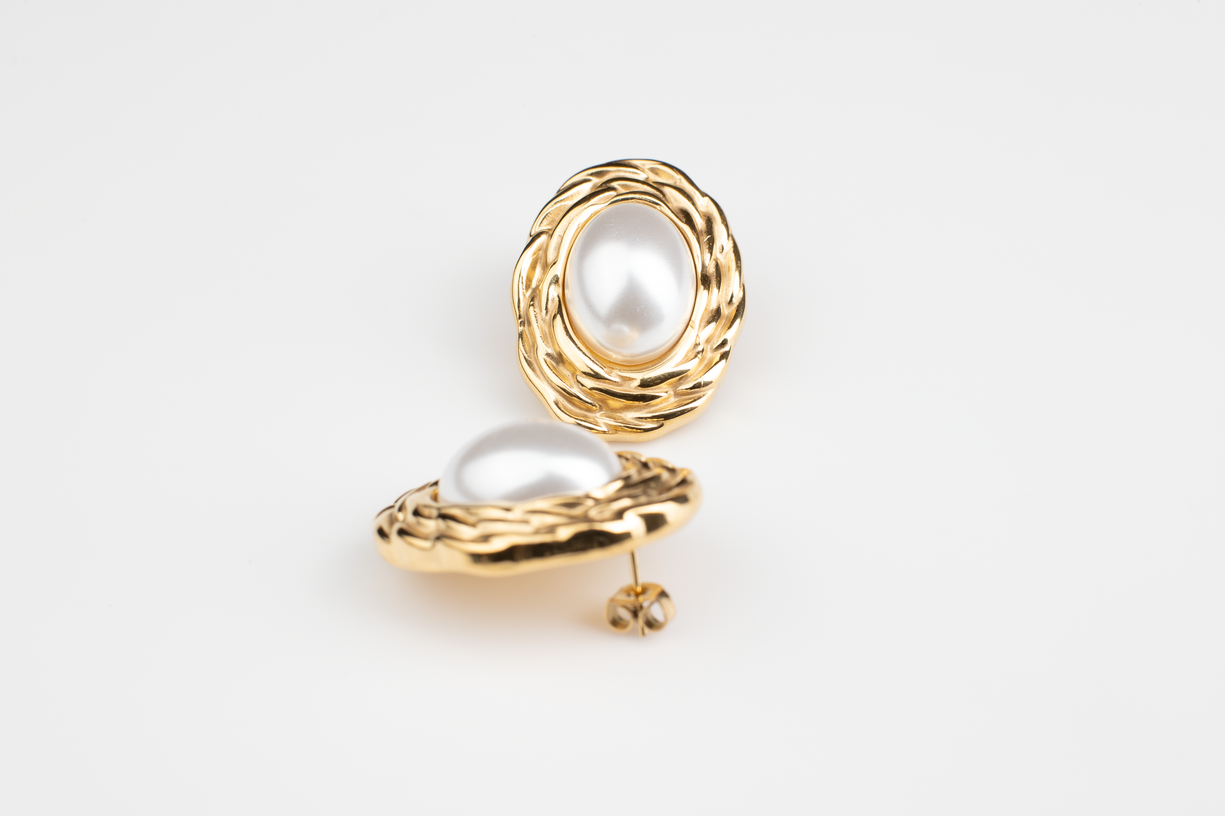 Discover timeless elegance with our classic pearl earrings. Featuring white pearls framed by delicate gold accents, these earrings exude sophistication and grace. Perfect for formal occasions, professional settings, or evening events, they effortlessly complement any attire, adding a touch of maturity and refinement. Ideal for women seeking refined accessories or as a thoughtful gift for someone special.