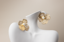 Indulge in luxury with our Floral Filigree Earrings. Crafted with intricate gold wire in the shape of blossoming flowers, each petal delicately hollowed to perfection. Adorned with a pristine white pearl at its center, these earrings exude sophistication and grace. Designed for women seeking elegance, they offer versatility with optional ear clips and are ideal for any occasion. Treat yourself or someone special to this exquisite accessory, a perfect gift choice.