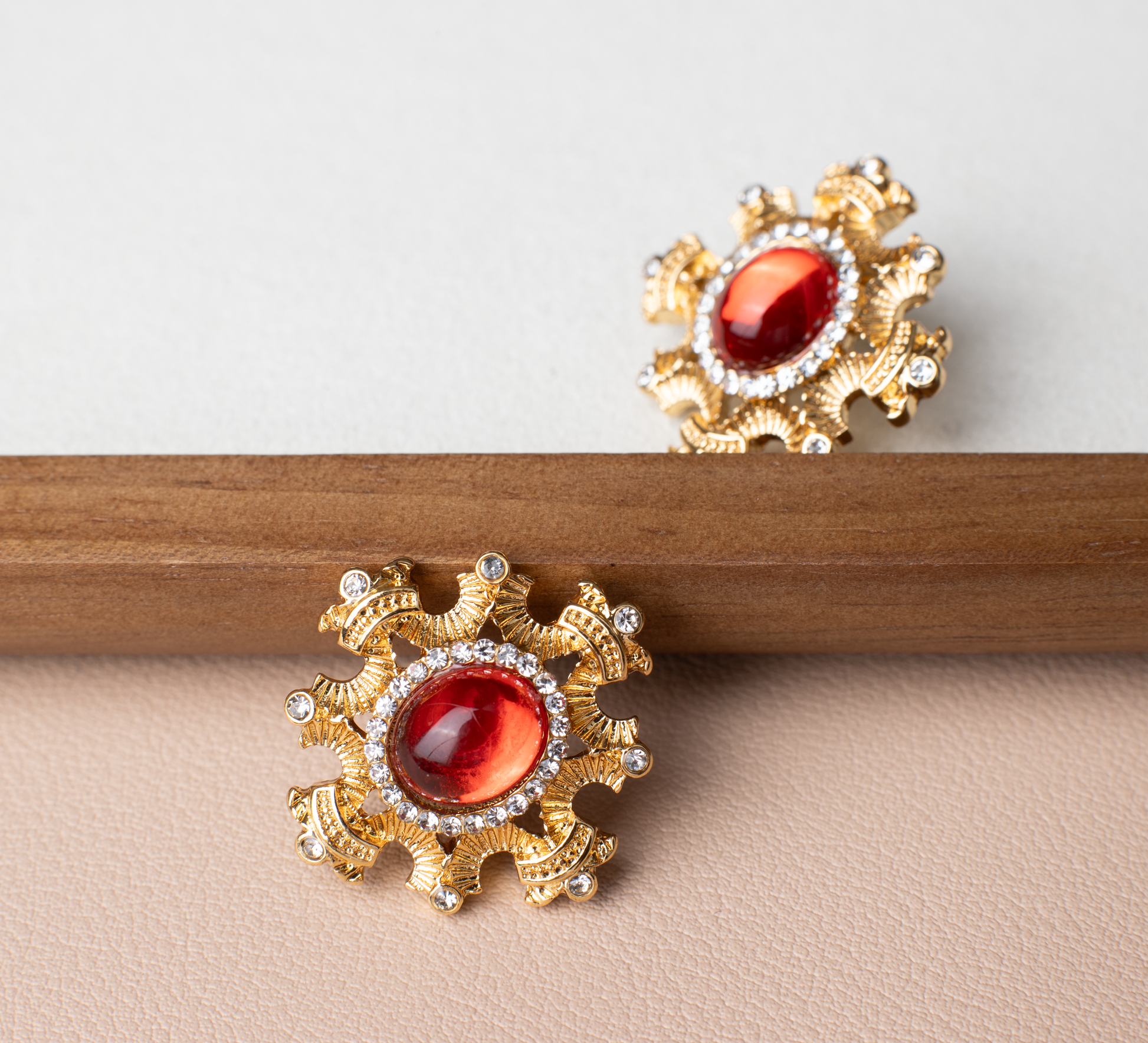 Adorn yourself with the regal elegance of red gemstone earrings encased in a blossoming gold frame. This bold and fiery design is suitable for various occasions, with the option of ear clips for added versatility. A perfect gift choice."